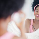 Happy Black Woman Smiling In Mirror