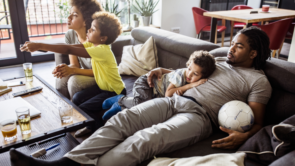 Black Family Enjoying Television On Couch